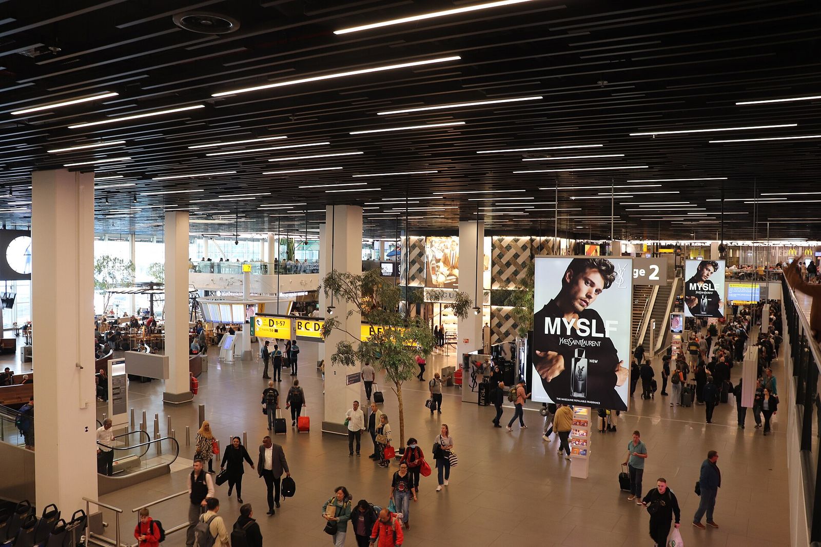 Reizigers met koffers in een hal van Schiphol
